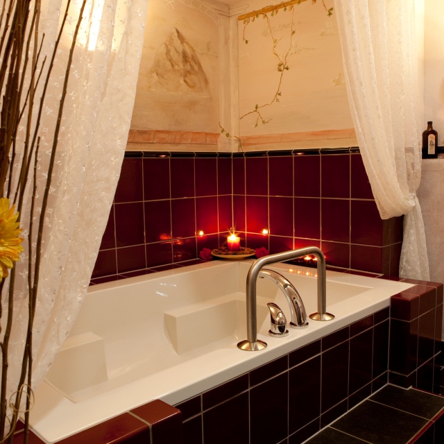 Sie sehen eine Badewanne im romantischen Kerzenschein.